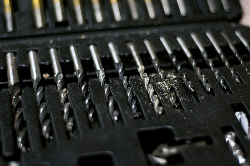 A close view of drill bits seated in the moulded slots of a black plastic index case
